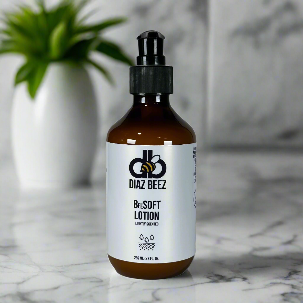 BeeSOFT Body Lotion bottle on a marble surface with a plant in the background.