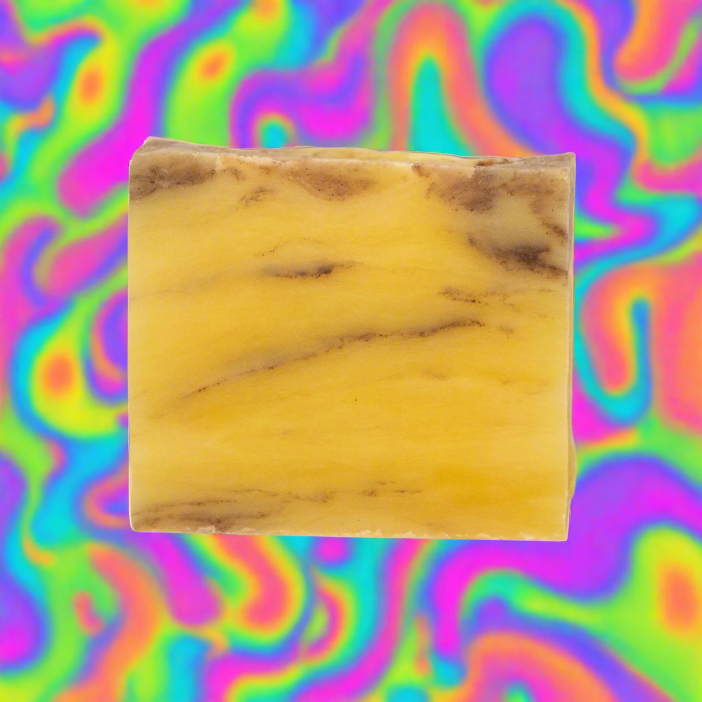 Burnt orange patchouli soap bar with vibrant citrus and earthy aroma, handcrafted with natural ingredients, on a colorful background.