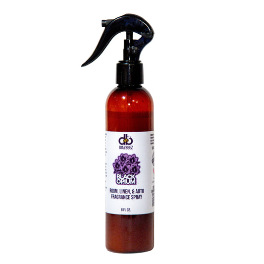 The "Black Opium Room, Linen, & Auto Fragrance Spray" by Diaz Beez features a captivating scent in a brown bottle equipped with a black nozzle. Its unisex fragrance is highlighted by the purple floral design on the label and it contains 8 fluid ounces.