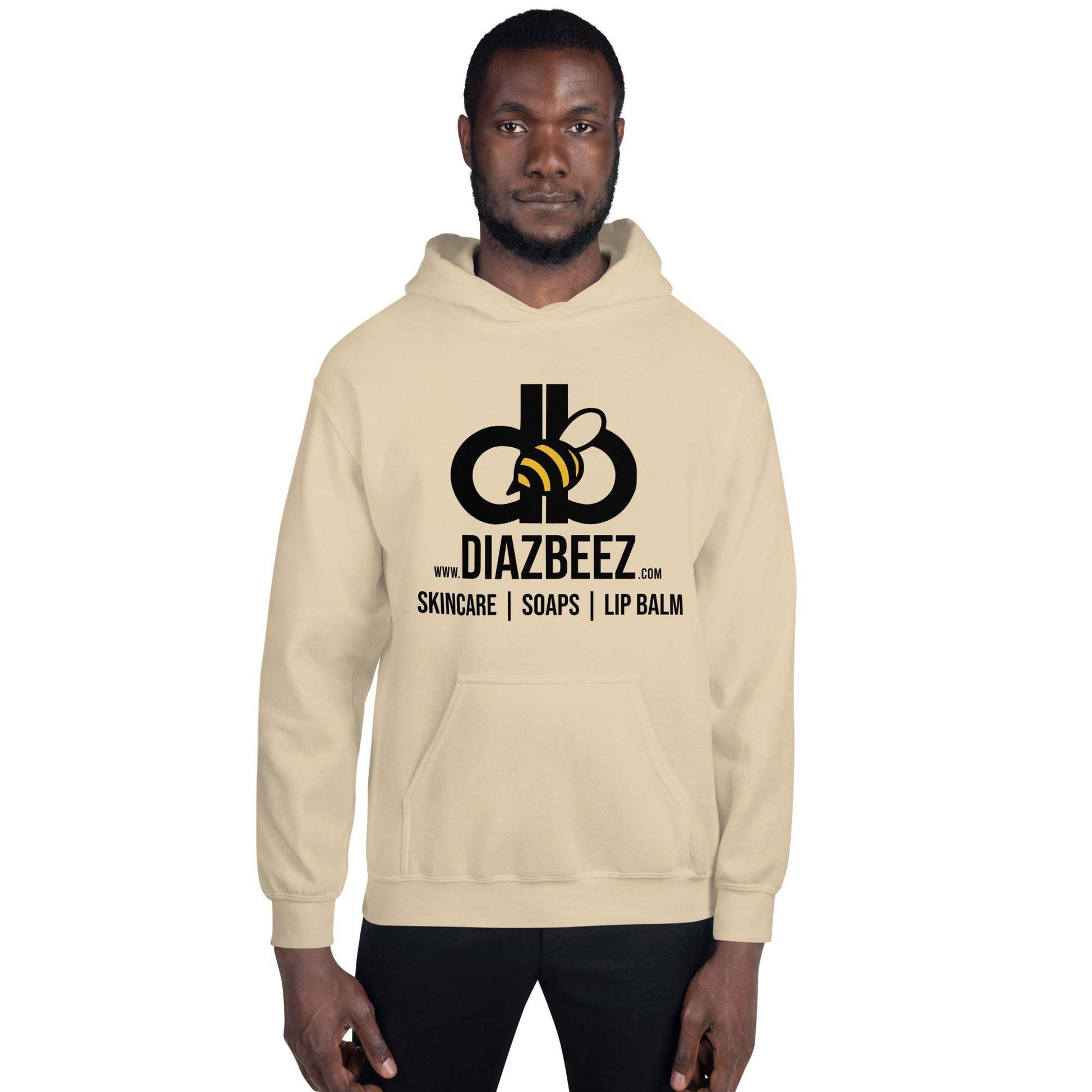 A man is wearing a comfortable and fashionable Diaz Beez Unisex Hoodie, adorned with the "DiazBeez.com" logo. The design reflects a beehive-inspired theme, promoting skincare products, soaps, and lip balm. He stands facing forward with a neutral expression.